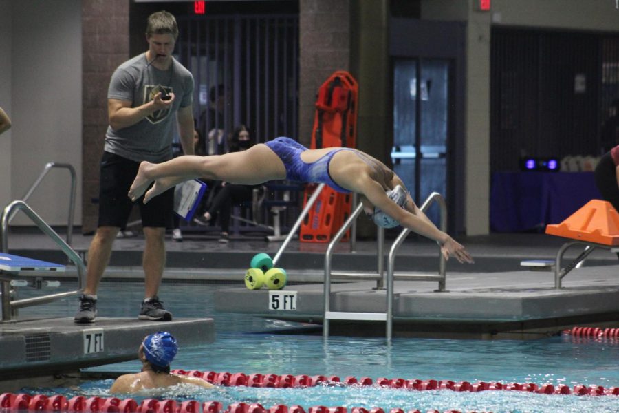 Coach Boland times swimmer, Megan Lam, as she dives for victory.