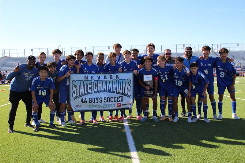 The Sierra Vista Mens soccer team with their championship banner and NIAA 4A trophy for a final photo, soaking up their time being champions.