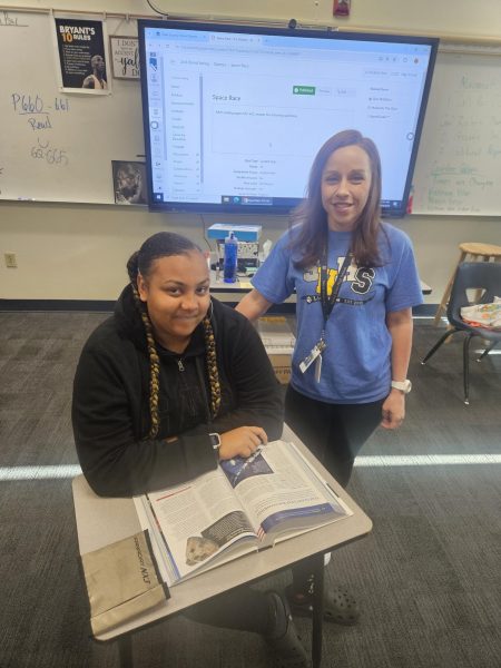 Ms. Beckham a US history teacher using the phone pouches during class with her student (11) Aaniyah Houston.