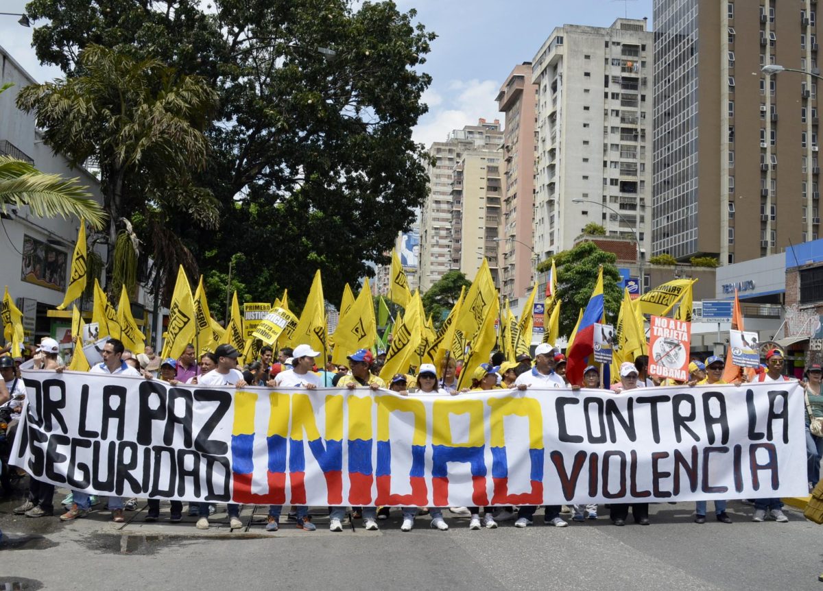 Civil Strife. Protesters holding a banner of the "Walk for Peace" march against Maduro's regime on October 14, 2014. (Credit: Carlos Díaz; Creative Commons License.)