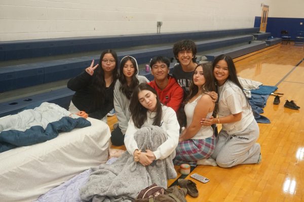 Seniors Chloe Gomez, Lexi Veleztan, Elijah Jurolan, Christian Rebolledo, Irina Jecova, Makenzie Best, and Mia Arielle pose in their pajamas, ready to spend the night in the school gym during lock-in.