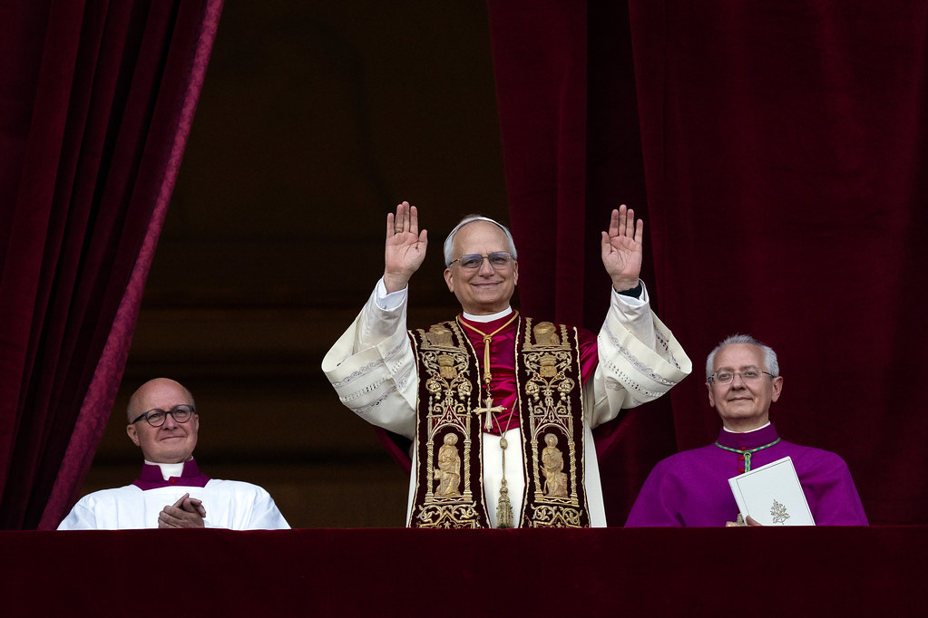 Pope Leo XIV makes his first public appearance standing at the central loggia of St. Peter's Basilica after his declaration as the 267th Head of the Catholic Church on May 8, 2025. Image sourced from Flickr, Creative Commons by NC-ND.

Link: https://www.flickr.com/photos/catholicism/54506387286/