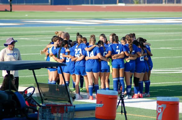 Prayers and passion. The team forms a huddle before a game, and recites a team prayer led by Hunter Hughes (11).
