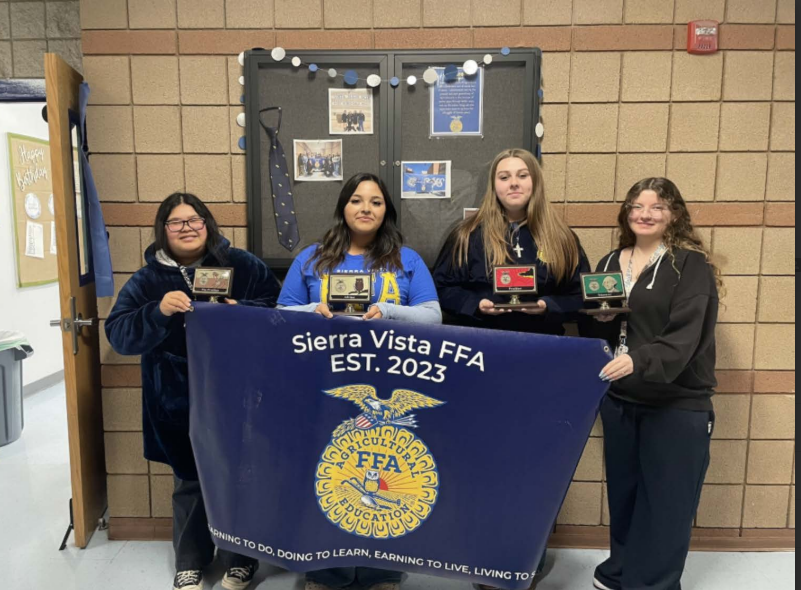 Future Farmers of America officers, Azalea Martinez(11), Hazel Valenzuela(11), Hailey Chagnon (11), and Alyssa Alvarez(11) show off their rankings and stand proud with the FFA flag.