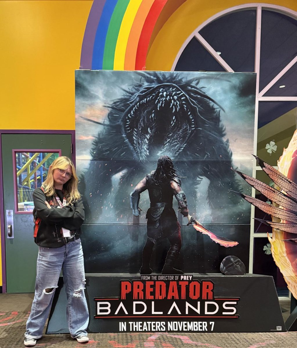 A pre-screening face-off: Farrah Ford (12) vs. the Predator: Badlands display.