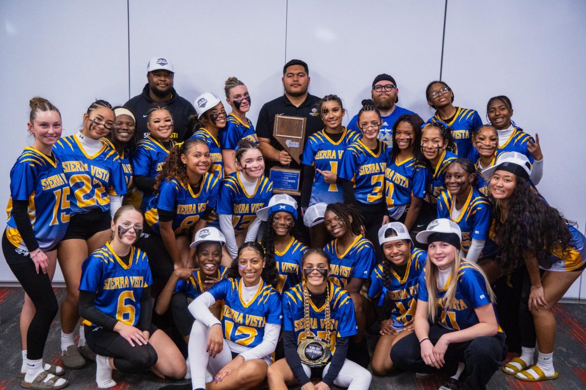 Sierra Vista Mountain Lion Flag Football celebrates alongside Head Coach Dan Bagwell, Coach Isosua Maika, and Coach Curry, as they proudly show off their new state championship trophy, reflecting the program's hard work and dedication throughout their successful season.